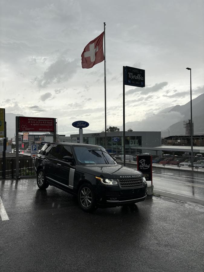 Michael’s Range Rover parked in the rain under a Swiss flag